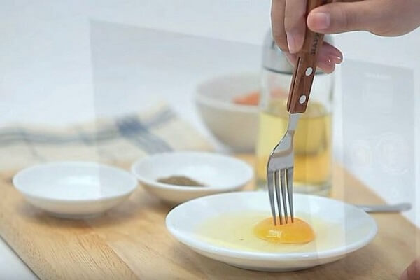 Sử dụng chiếc nĩa nhỏ xăm ở giữa lòng trứng tạo thành lỗ